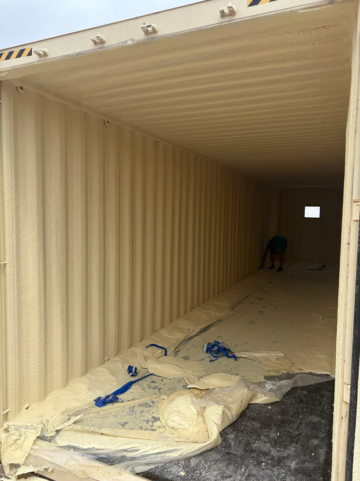 Interior of an insulated shipping container with spray foam insulation lining the walls and ceiling near Waco Texas